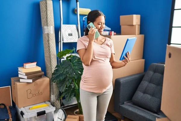 Mladý Latina Žena Těhotná Pomocí Touchpad Mluvit Smartphone Novém Domově — Stock fotografie