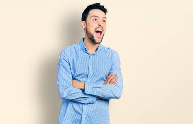 Kollarını kavuşturmuş İspanyol sakallı bir adam kızgın ve kızgın bir şekilde bağırıyor ve öfkeliydi. Öfkeyle bağırıyordu.. 