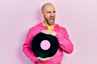 Elinde vinil disk tutan genç kel adam kızgın ve kızgın çığlık atıyor sinirli ve öfkeliydi, öfkeyle bağırıyordu. öfke ve agresif konsept. 