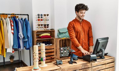 Genç İspanyol esnaf mağazada çalışırken gülümsüyor..