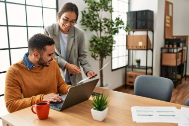 Ofiste masa başında çalışırken gülümseyen iki iş adamı..