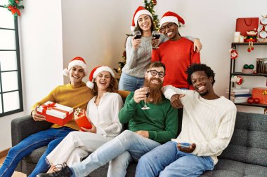 Bir grup genç Noel kutlaması için evdeki kanepede oturuyor..