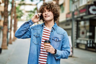 Genç İspanyol adam şehirde telefonla konuşuyor.