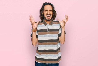 Gündelik kıyafetler giyen genç İspanyol adam başarı için deli ve çılgınlığı kutluyor kollarını kaldırmış ve gözlerini kapatmış heyecanla bağırıyor. Kazanan konsept 