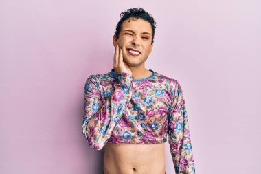 Makyaj yapıp makyaj yapan yakışıklı bir adam diş ağrısı ya da diş hastalığından dolayı ağızlarına acı dolu bir ifadeyle dokunuyor. dişçi 