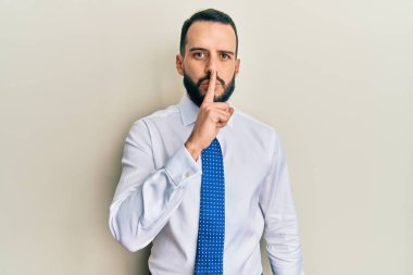 Sakallı, iş kravatlı genç adam sessiz olmak istiyor. sessizlik ve gizli konsept. 