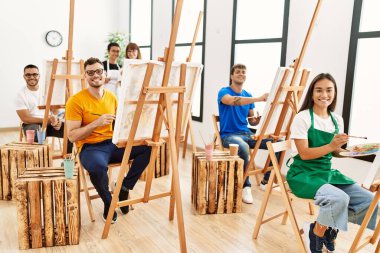 Sanat stüdyosunda mutlu çizimler yapan bir grup insan..