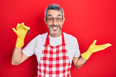 Gri saçlı, beyaz saçlı, elinde hamamböceği olan yakışıklı orta yaşlı bir adam zaferi mutlu bir gülümsemeyle kutluyor ve ellerini kaldırarak kazanan bir ifade sergiliyor. 