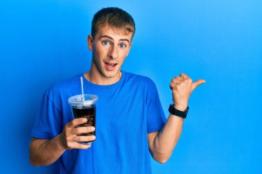 Kafkasyalı genç adam bir bardak meşrubat içiyor. Parmağını kaldırıyor, gülümsüyor, ağzı açık. 
