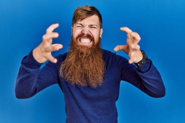 Uzun sakallı, mavi arka planda sıradan mavi süveter giyen, öfkeden kudurmuş elleri boğazlamaya çalışan, deli gibi bağıran kızıl saçlı bir adam. 