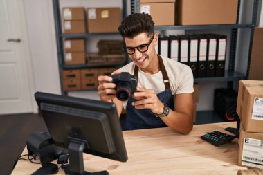 Ofiste profesyonel kamera kullanan Latin asıllı genç bir iş adamı.