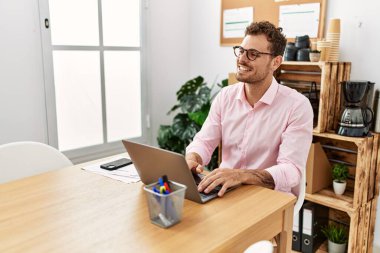 Ofiste çalışırken gülümseyen İspanyol genç adam.