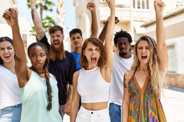 Bir grup genç eylemci şehirde yumruklarını kaldırarak protesto ediyor..