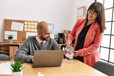 İki İspanyol iş adamı mutlu gülümsüyor. Ofise su döken ortak..