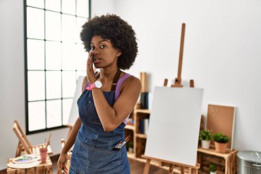 Afro saçlı genç Afrikalı Amerikalı kadın sanat stüdyosunda el ele tutuşup gizli dedikodular anlatıyor, kötü niyetli konuşmalar fısıldıyor. 