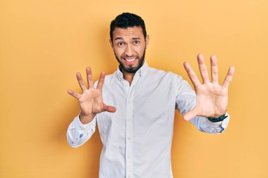 Sakallı, iş gömleği giyen, korku ifadesinden korkan ve dehşete düşmüş İspanyol bir adam elleriyle hareket etmeyi kes, şok içinde bağır. panik konsepti. 