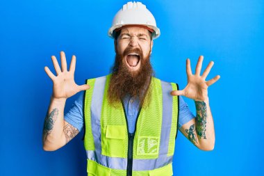 Uzun sakallı, güvenlik kaskı takan ve ceketini yansıtan kızıl saçlı adam başarıyı kolları havada ve gözleri kapalı heyecanla haykırarak kutluyor. Kazanan konsept 
