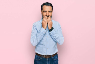 İş gömleği giyen, sakallı orta yaşlı bir adam gülüyor ve utanıyor kıkırdıyor elleriyle ağzını kapatıyor, dedikodu yapıyor ve skandal konsepti yapıyor. 