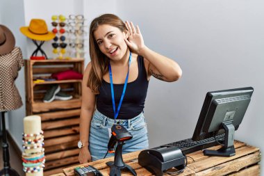 Genç esmer kadın perakende dükkanında açık mesajla pankart tutuyor. Kulaktan kulağa gülümsüyor. Dedikoduları ve dedikoduları dinliyor. Sağırlık kavramı. 