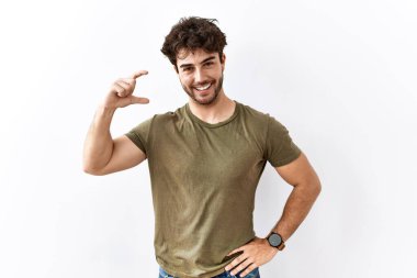 İzole edilmiş beyaz arka planda duran İspanyol adam gülümsüyor ve el hareketleriyle hareket ediyor parmaklarıyla işaret yapıyor ve kameraya bakıyor. ölçüm kavramı. 