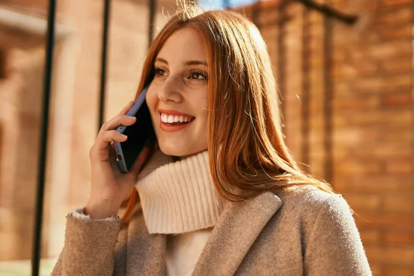 若いです赤毛の女の子笑顔幸せな話上のスマートフォンで街 — ストック写真