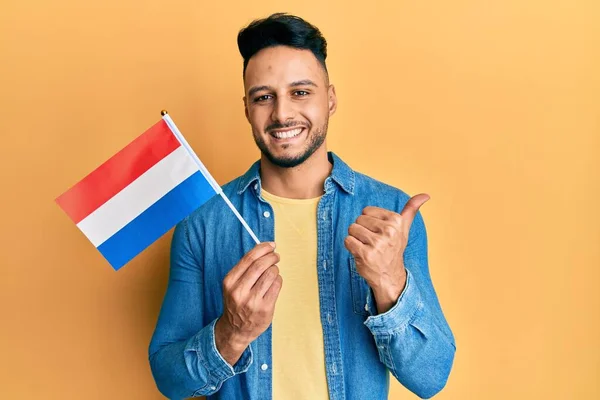Hollanda Bayrağı Taşıyan Genç Arap Adam Mutlu Olumlu Gülümsüyor Başparmağıyla — Stok fotoğraf