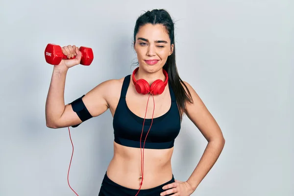 Menina Hispânica Jovem Vestindo Sportswear Usando Haltere Piscando Olhando Para — Fotografia de Stock