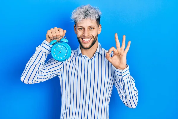 Joven Hombre Hispano Con Pelo Teñido Moderno Sosteniendo Despertador Haciendo —  Fotos de Stock