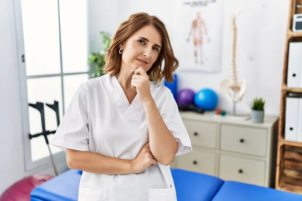 Middle Age Physiotherapist Woman Working Pain Recovery Clinic Looking Confident — Stock Photo, Image