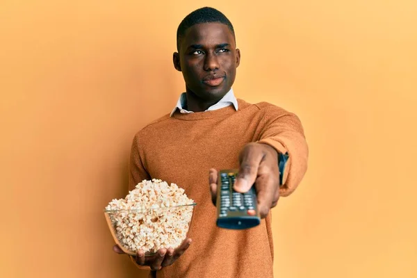 Joven Hombre Afroamericano Sosteniendo Televisión Control Remoto Comiendo Palomitas Sonriendo — Foto de Stock