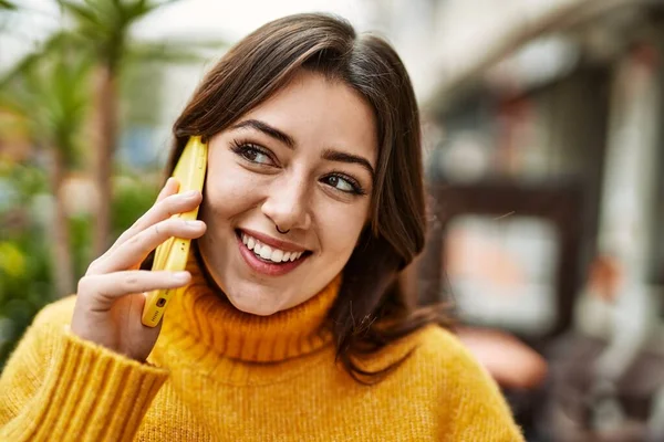 若いです美しいですブルネット女性身に着けていますTurtleeckセーター屋外で話す上の電話 — ストック写真