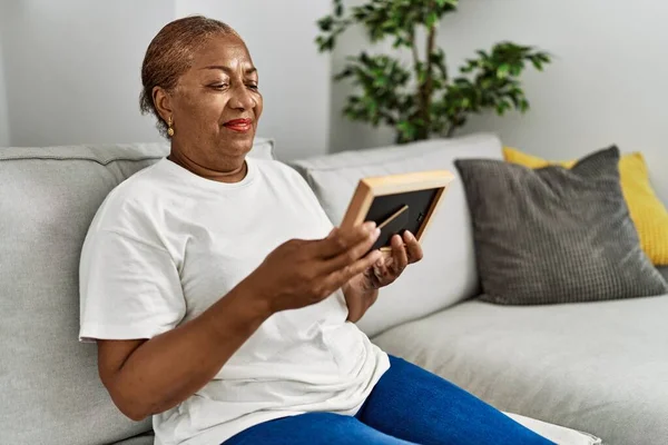 Senior Αφροαμερικανή Γυναίκα Ψάχνει Φωτογραφία Κάθεται Στον Καναπέ Στο Σπίτι — Φωτογραφία Αρχείου
