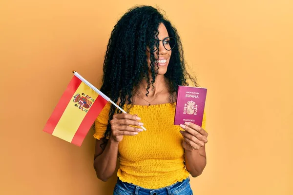 Mujer Afroamericana Mediana Edad Sosteniendo Bandera España Pasaporte Sonriendo Mirando —  Fotos de Stock