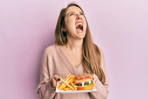 Mujer Rubia Joven Comiendo Una Sabrosa Hamburguesa Clásica Con Papas —  Fotos de Stock