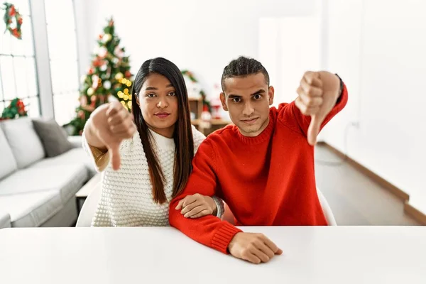 Jong Latijns Paar Zit Tafel Door Kerstboom Kijken Ongelukkig Boos — Stockfoto