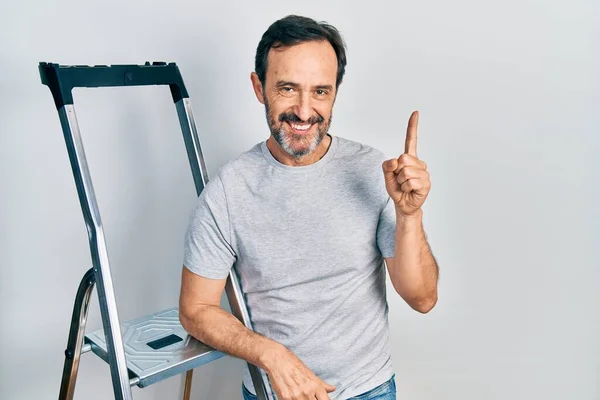 Hombre Hispano Mediana Edad Usando Escalera Sorprendido Con Una Idea —  Fotos de Stock