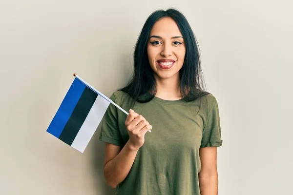 Menina Hispânica Jovem Segurando Bandeira Estonia Olhando Positivo Feliz Sorrindo — Fotografia de Stock