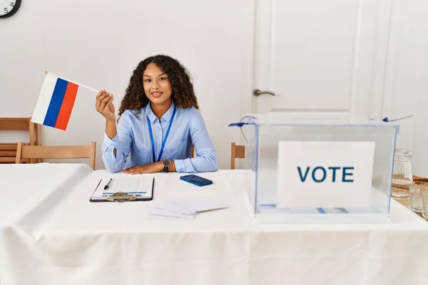 Joven Latina Sonriendo Confiada Sosteniendo Bandera Rusa Trabajando Colegio Electoral —  Fotos de Stock