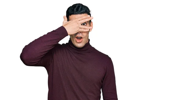 Hezký Hispánský Muž Neformálním Rolákovém Svetru Vykukuje Šoku Zakrývá Obličej — Stock fotografie