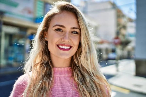 年轻的金发女人对着城市微笑 — 图库照片