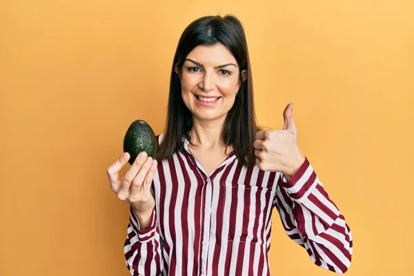Giovane Donna Ispanica Che Tiene Avocado Sorridente Felice Positivo Pollice — Foto Stock