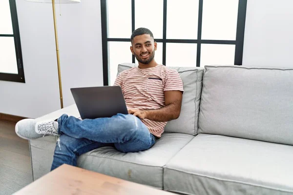 Молодий Арабський Чоловік Посміхається Впевнено Використовуючи Ноутбук Вдома — стокове фото