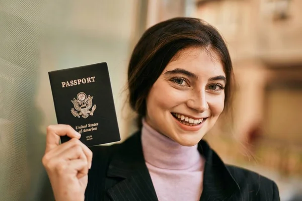 年轻美丽的女商人笑着高高兴兴地在城里持着美国护照 — 图库照片
