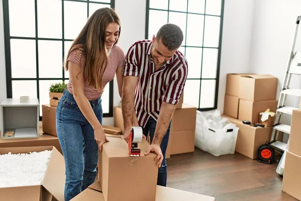 Joven Pareja Hispana Sonriendo Feliz Embalaje Caja Cartón Nuevo Hogar — Foto de Stock