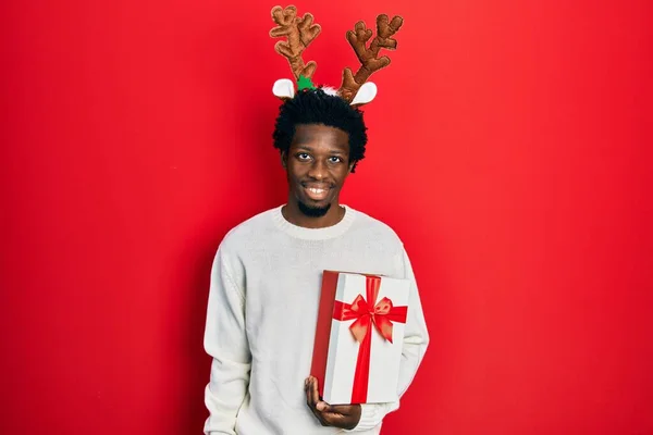 Jovem Afro Americano Vestindo Chapéu Natal Veado Segurando Presente Com — Fotografia de Stock