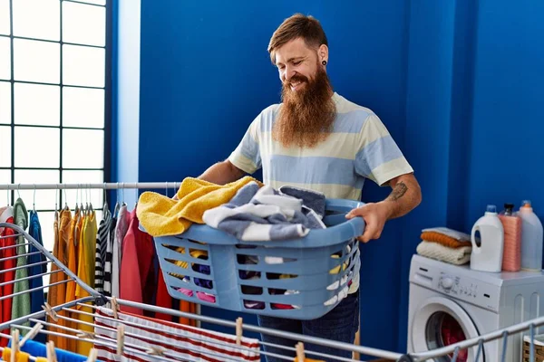 Jovem Ruiva Sorrindo Confiante Segurando Cesta Com Roupas Lavanderia — Fotografia de Stock