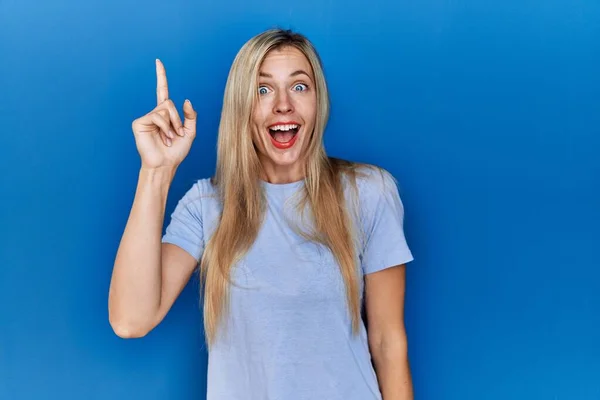 Schöne Blonde Frau Lässigem Shirt Über Blauem Hintergrund Zeigt Mit — Stockfoto