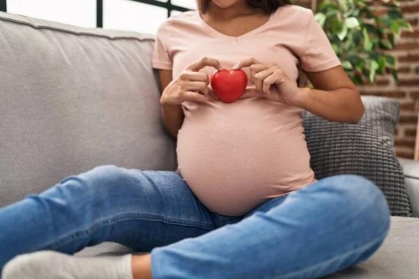 Ung Latinamerikansk Kvinna Gravid Håller Hjärtat Sitter Soffan Hemma — Stockfoto