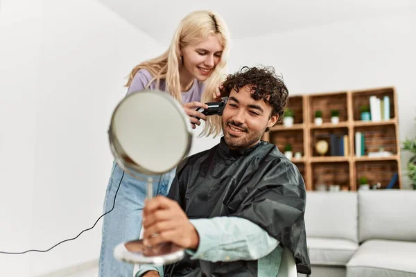年轻女子在家里给男朋友剪头发 — 图库照片