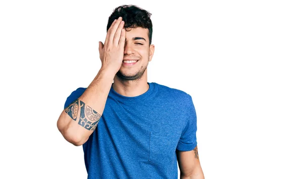 Jovem Hispânico Vestindo Camiseta Casual Cobrindo Olho Com Mão Sorriso — Fotografia de Stock